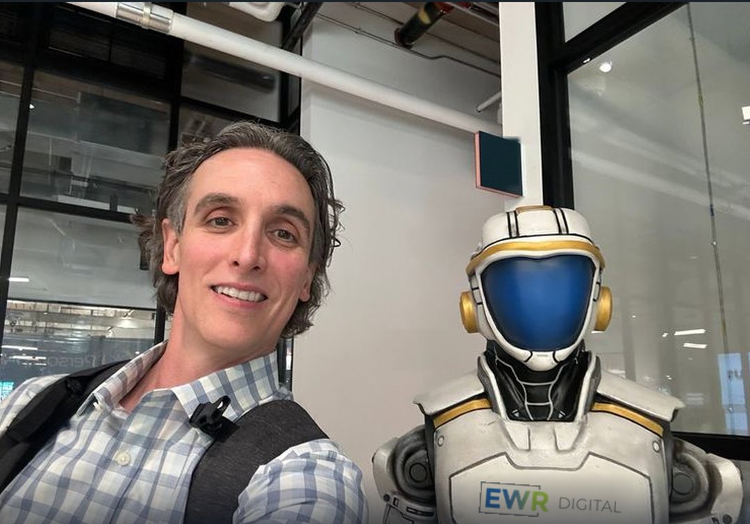 Matthew Bertram with an EWR Digital branded humanoid robot - oil & gas AI keynote speaker
