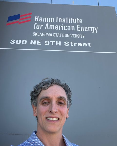 Matt Bertram outside the Hamm Institute for American Energy, under the building sign reading Oklahoma State University, 300 NE 9th Street